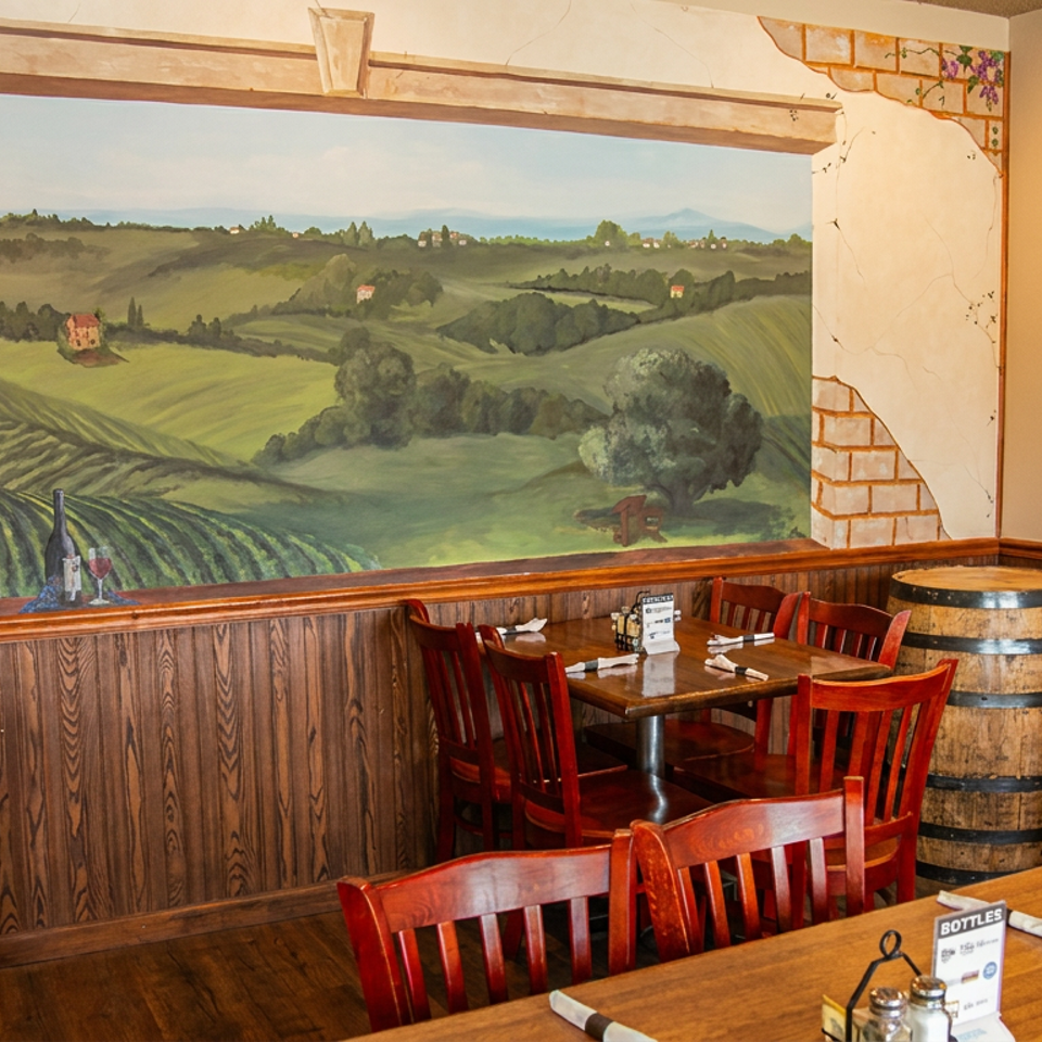Restaurant dining area with wooden tables and chairs, featuring a large mural of a vineyard landscape.